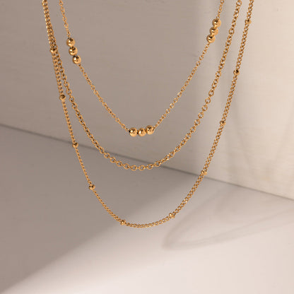 Two gold chains on a neutral background