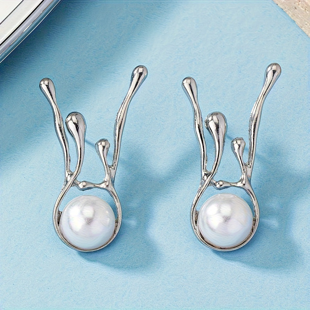 Silver earrings with pearl drops on a light blue background