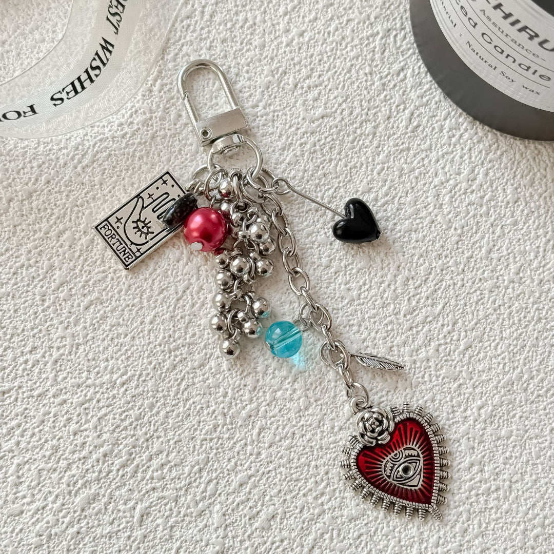 Keychain with heart-shaped charm and beads on a textured white surface