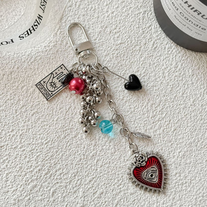 Keychain with heart-shaped charm and beads on a textured white surface