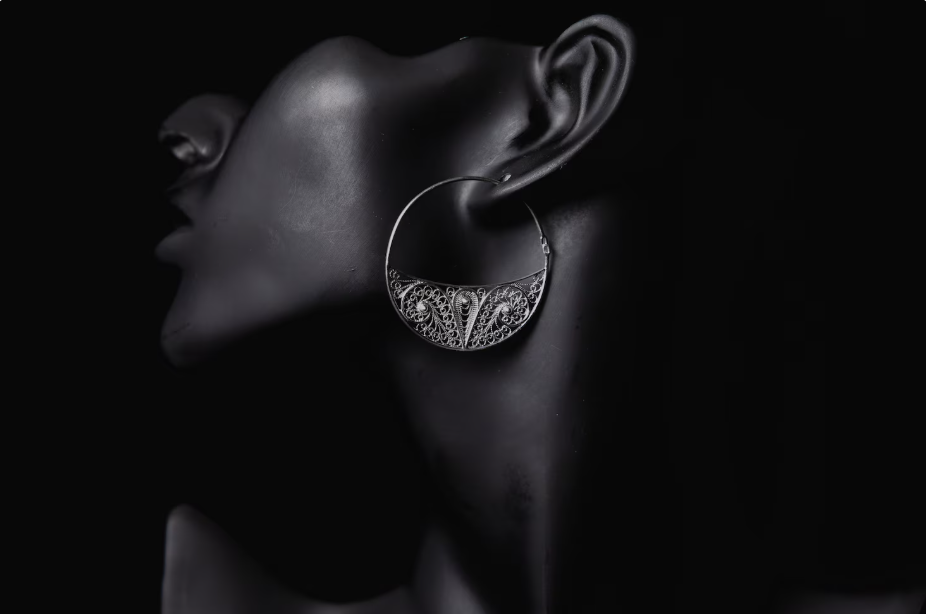 Silver hoop earring on a black background
