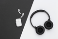 Black headphones and white earbuds on a black and white background