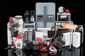 Collection of various home appliances on a reflective surface with a black background