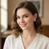 Woman wearing gold jewelry with a blurred indoor background