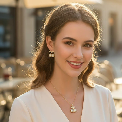 Woman wearing a necklace and earrings with a blurred outdoor background