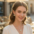 Woman wearing a necklace and earrings with a blurred outdoor background